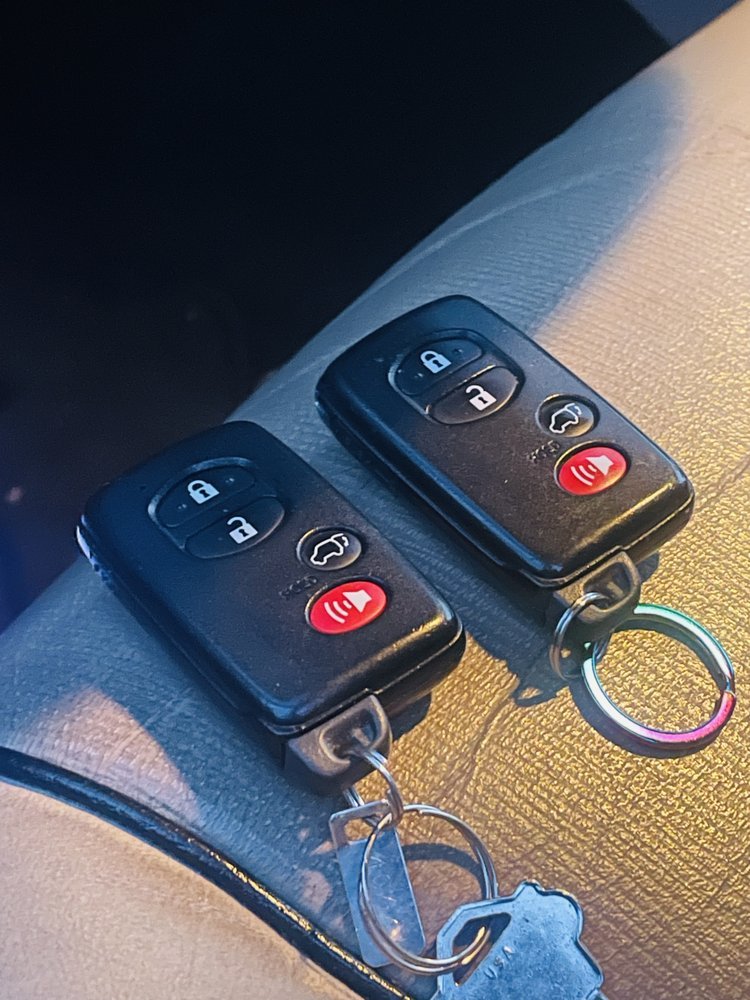 A pair of smart keys on a car dashboard at dusk