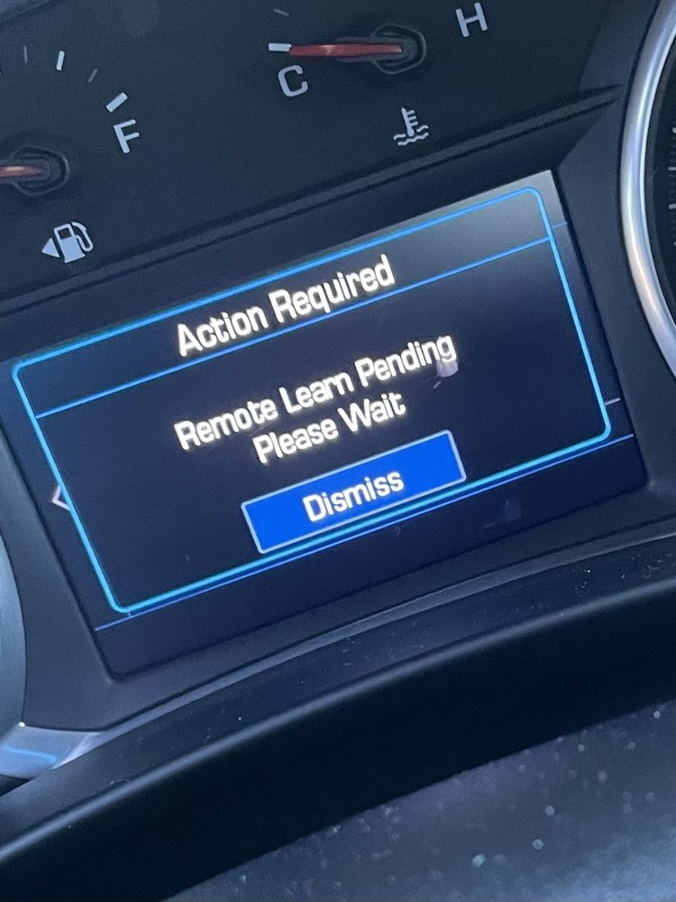 A car instrument cluster showing Remote Learn Pending while a new remote is paired