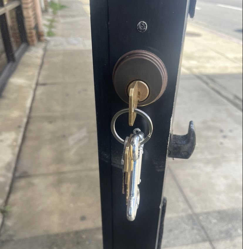 A door lock with a ring of keys hanging from the cylinder