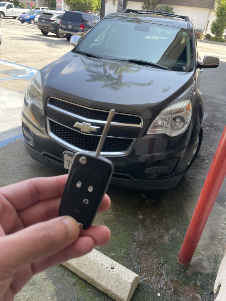 A new flip key held up in front of the customer's SUV